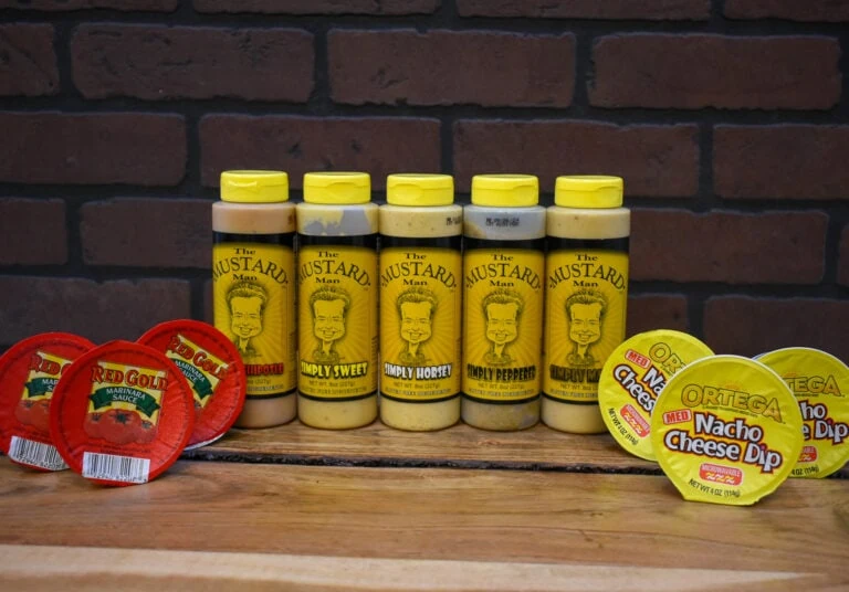 Selection of Campbell Creek dips displayed on a wooden table with a brick wall in the background.